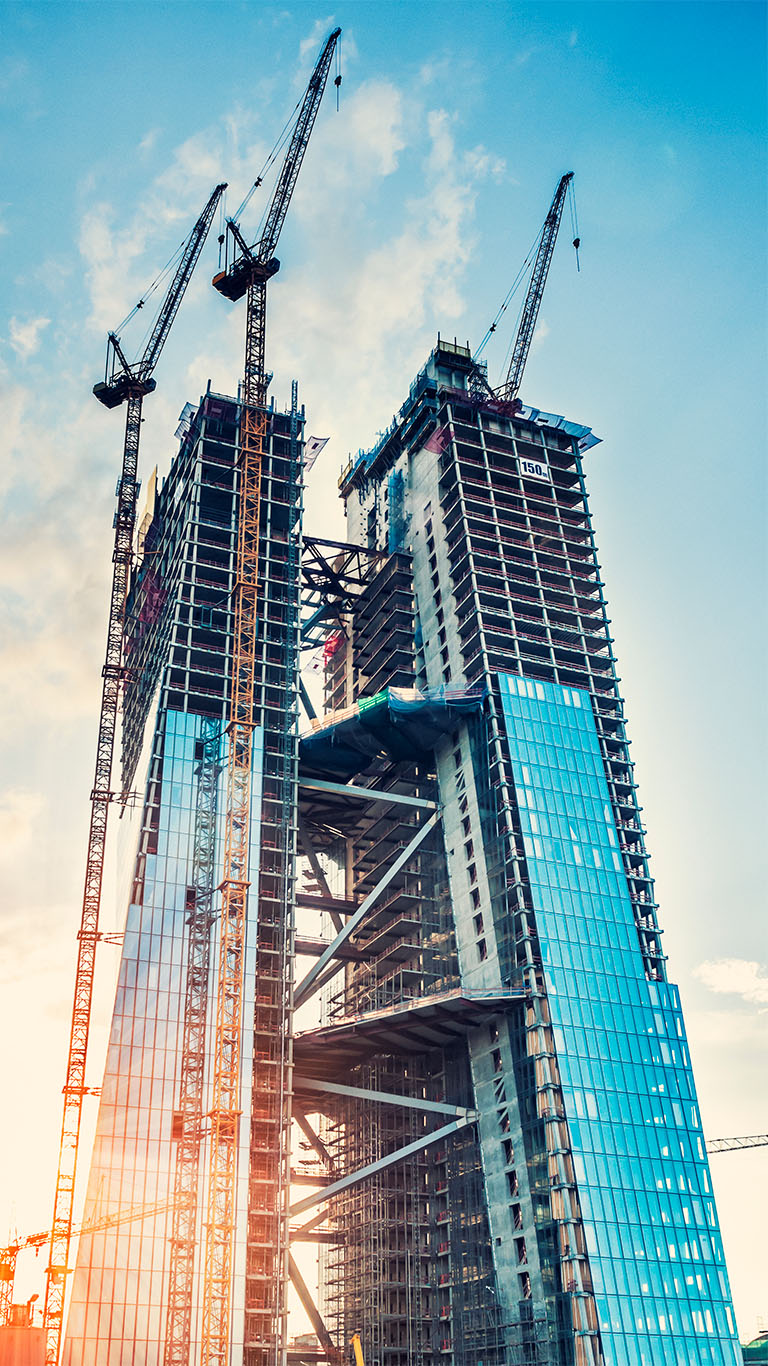 tall glass office building under construction